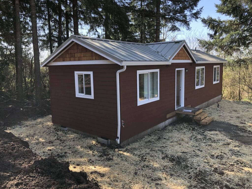 Red and white Wolf Model E home with cedar shake gables.