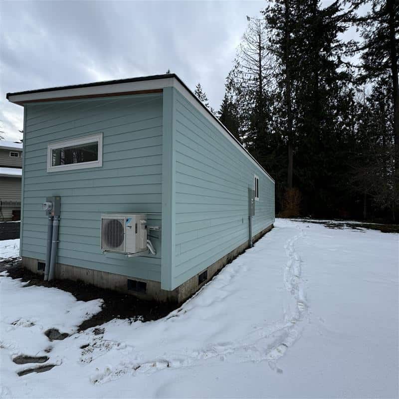 Green and white Wolf Model E home in the snow.