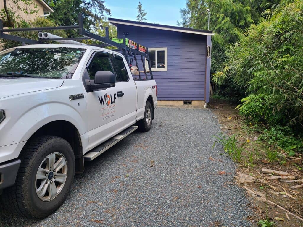 Blue and white Model E with a Wolf truck in front.