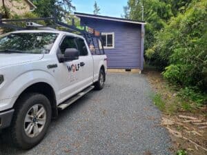 Blue and white Model E with a Wolf truck in front.