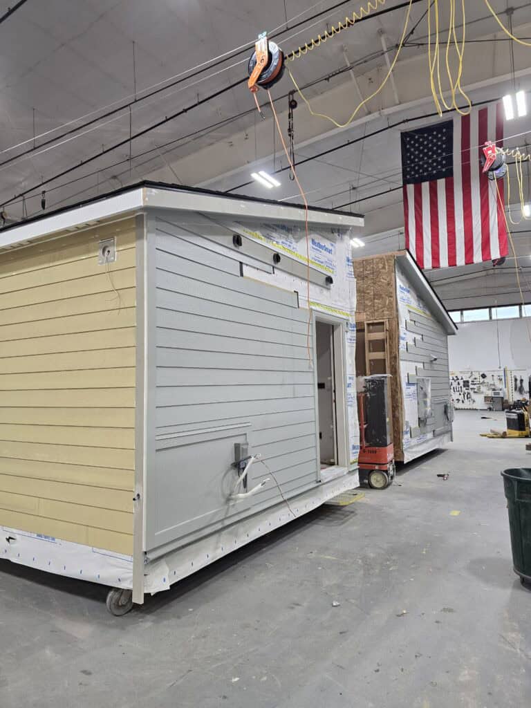 Wolf Model L module with partial siding and housewrap still on, inside the shop.