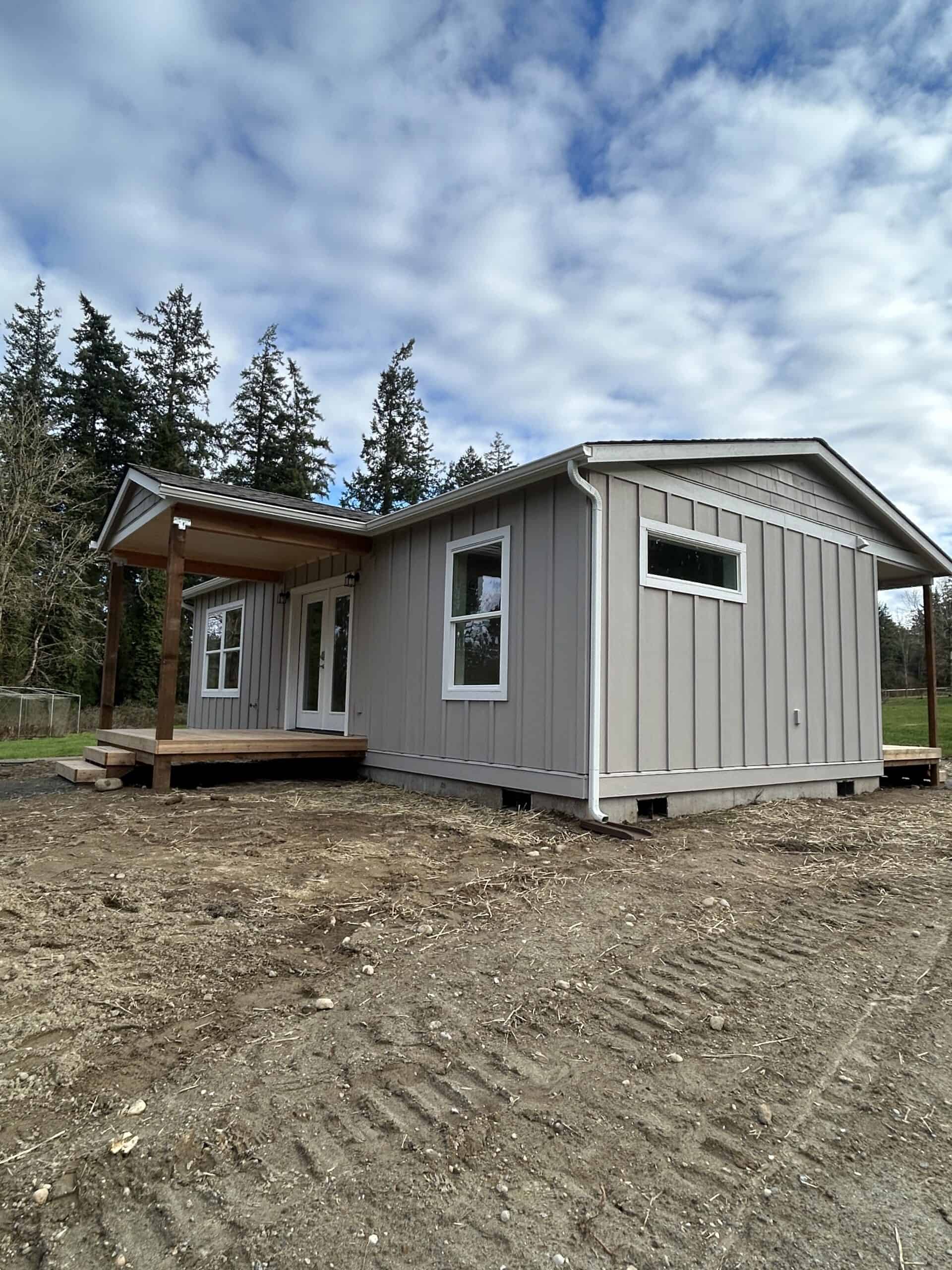Wolf Model J home with covered porch deck and board and batten siding.