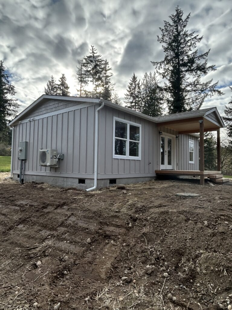 Wolf Model J home with covered porch deck and board and batten siding.