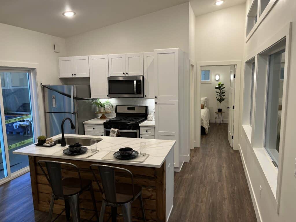 Island kitchen from front entry looking toward primary bedroom in a Wolf Model E home.