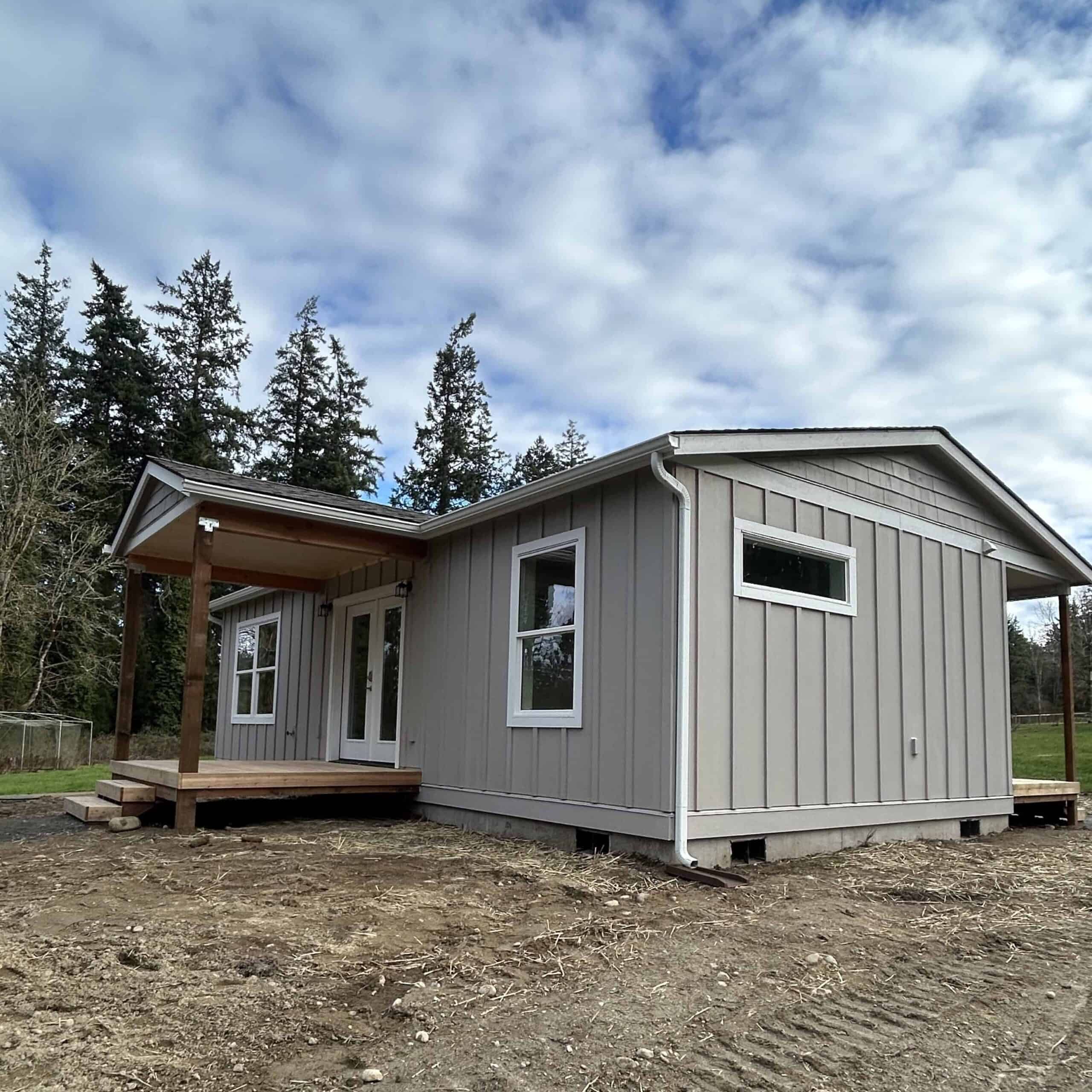 Wolf Model J home with covered porch deck and board and batten siding.