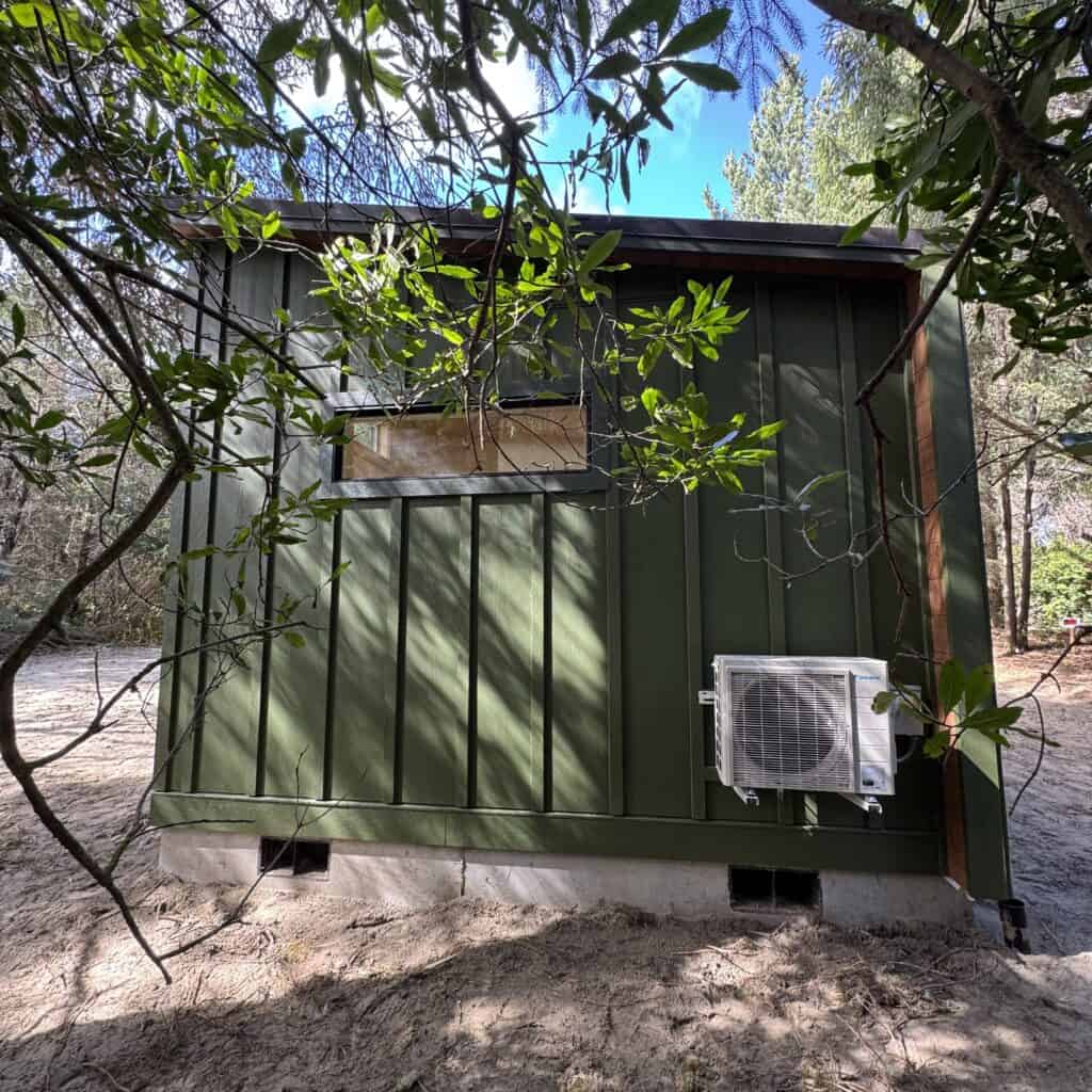 Green Wolf Model F home with board and batten siding and metal shed roof.