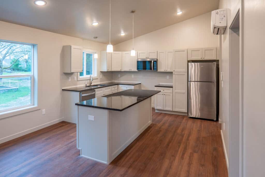 Island kitchen with black quartz countertops in a Wolf Model L home.