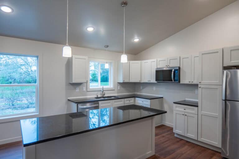 Island kitchen with black quartz countertops in a Wolf Model L home.