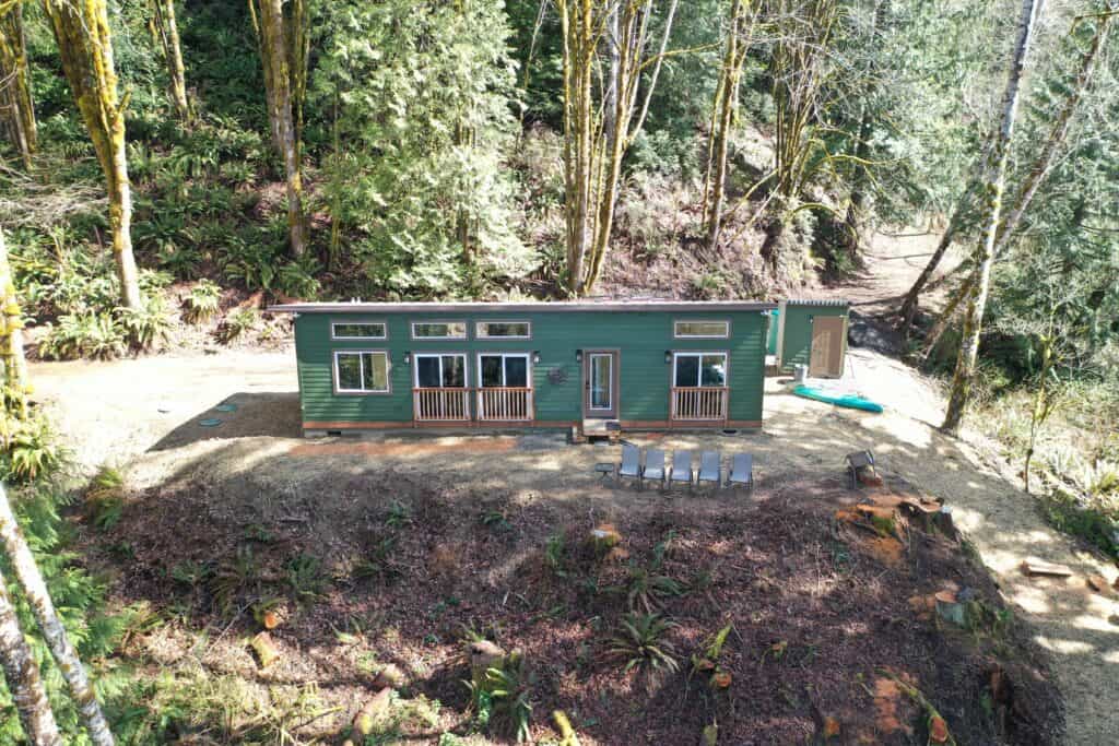 Green Wolf Model E home with 3 sliding glass windows and a great view.