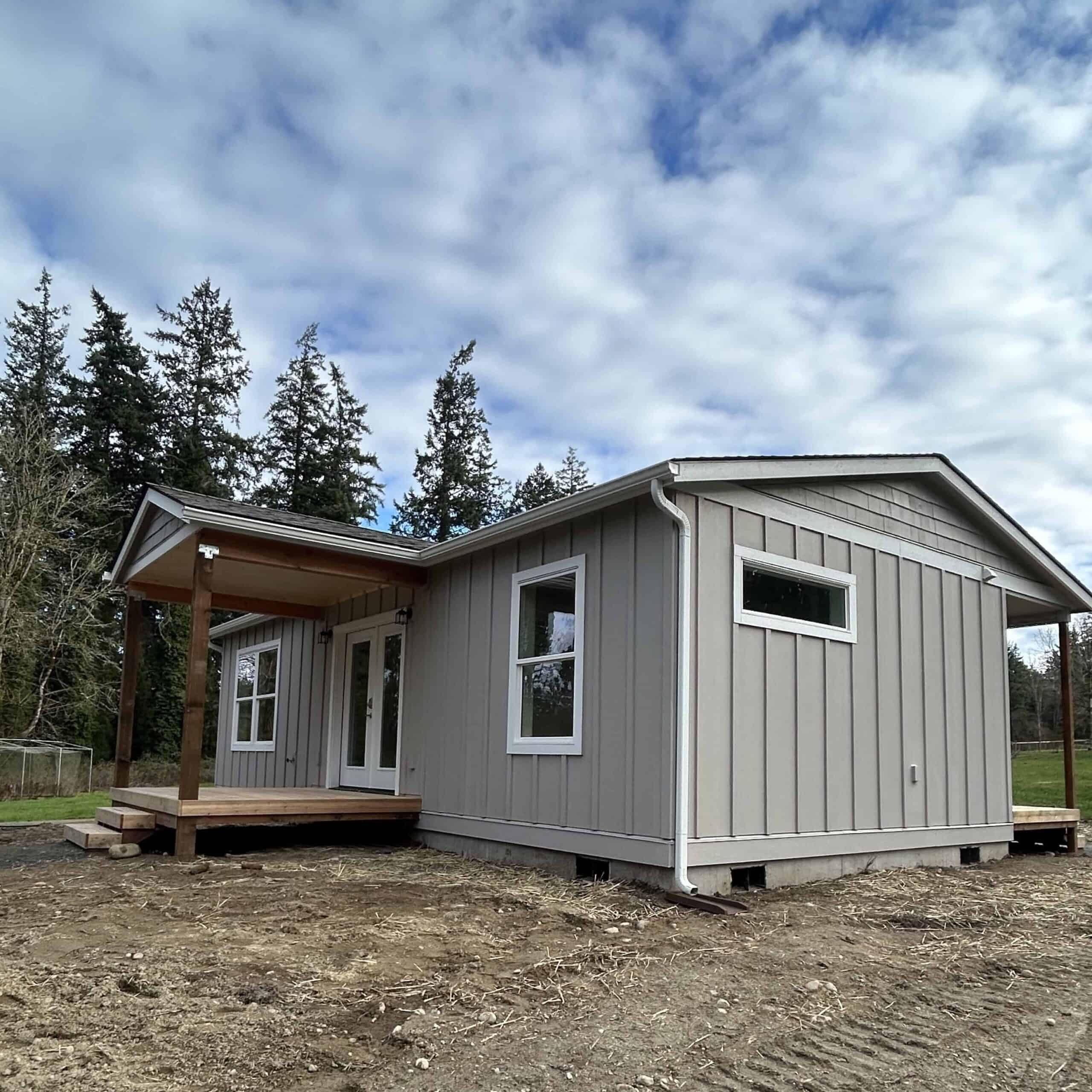 Wolf Model J home with covered porch deck and board and batten siding.