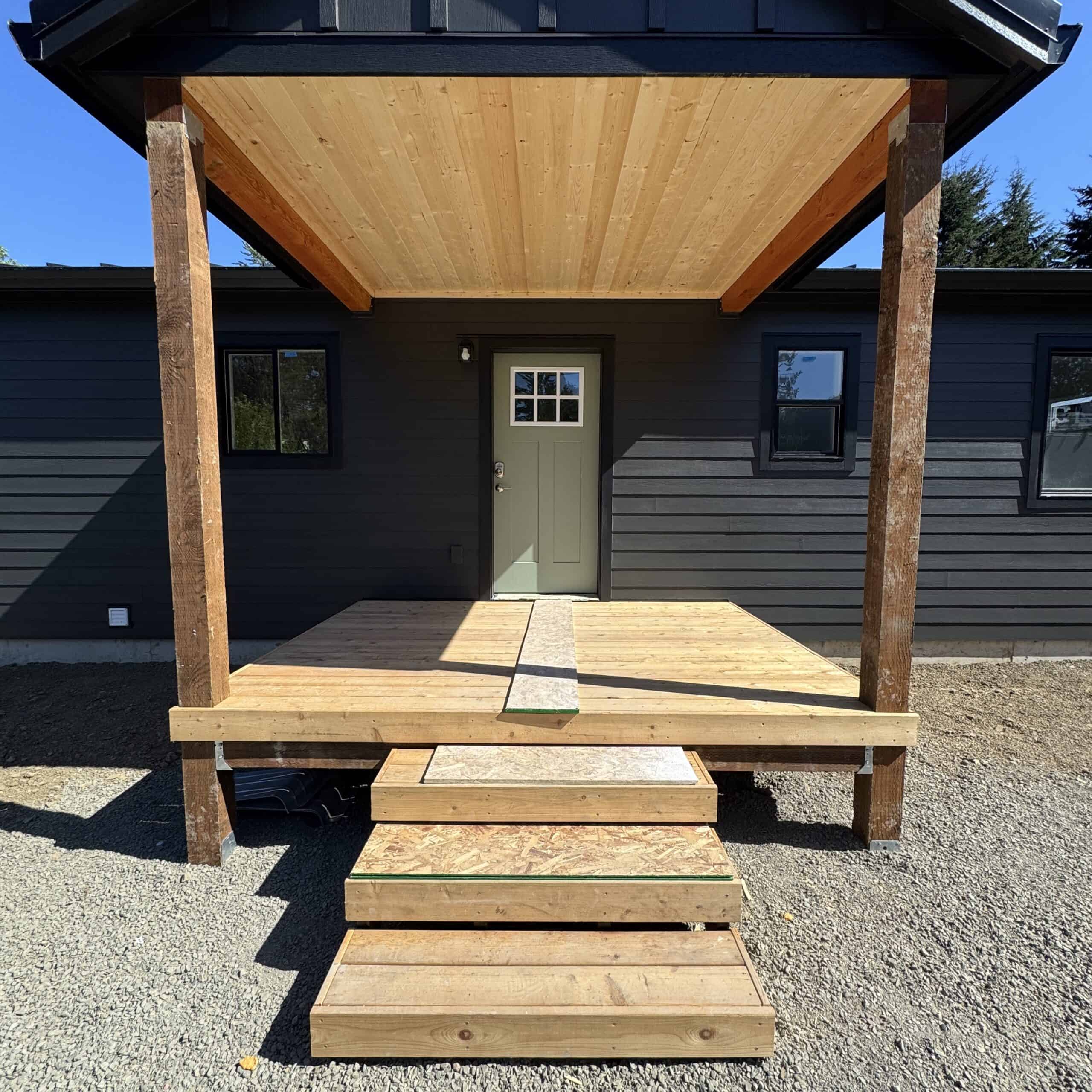 Black Wolf Model I home with covered porch deck.