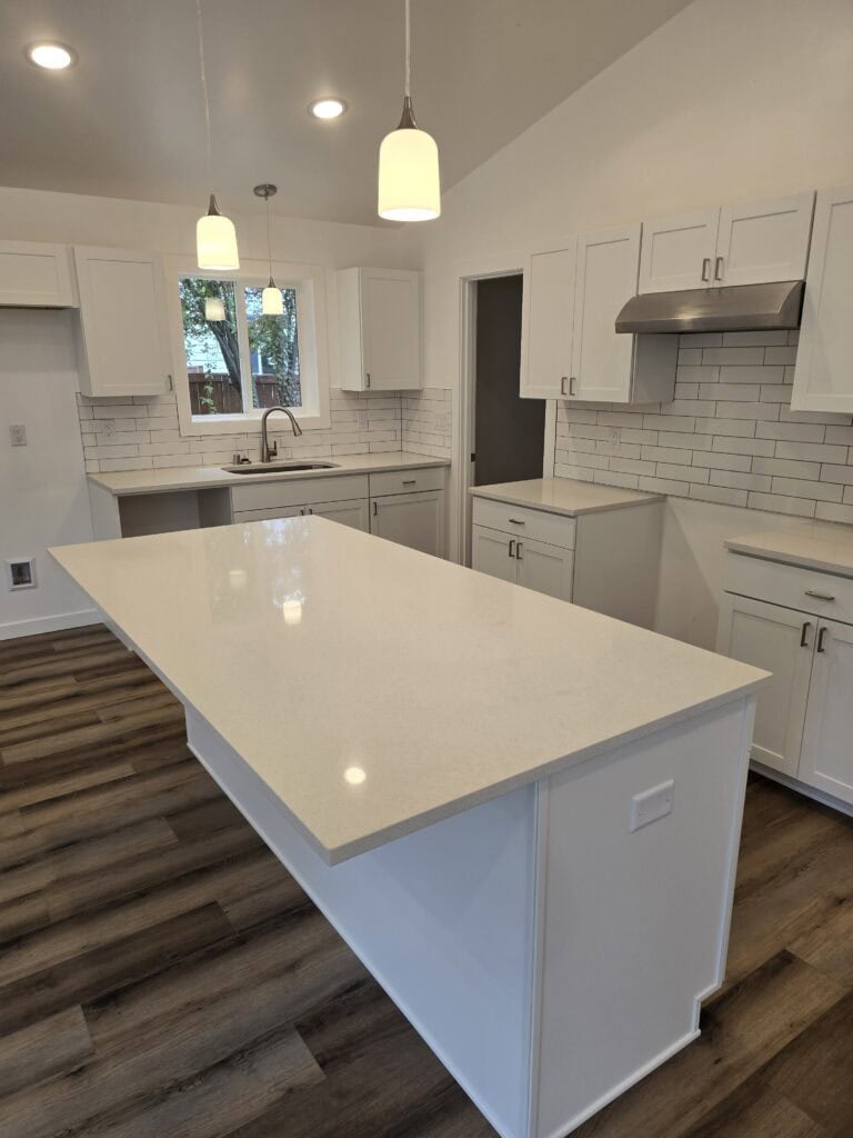 L-shaped island kitchen with tile backsplash in a Wolf Model I modular home.