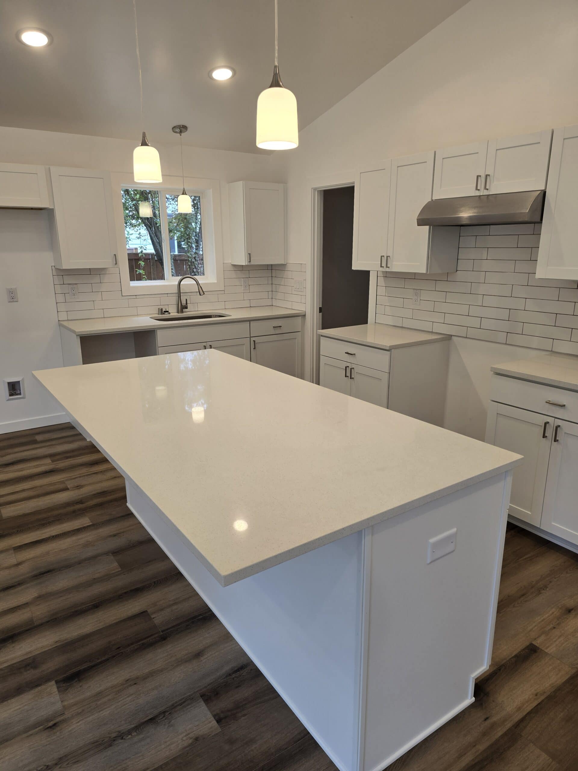 L-shaped island kitchen with tile backsplash in a Wolf Model I modular home.