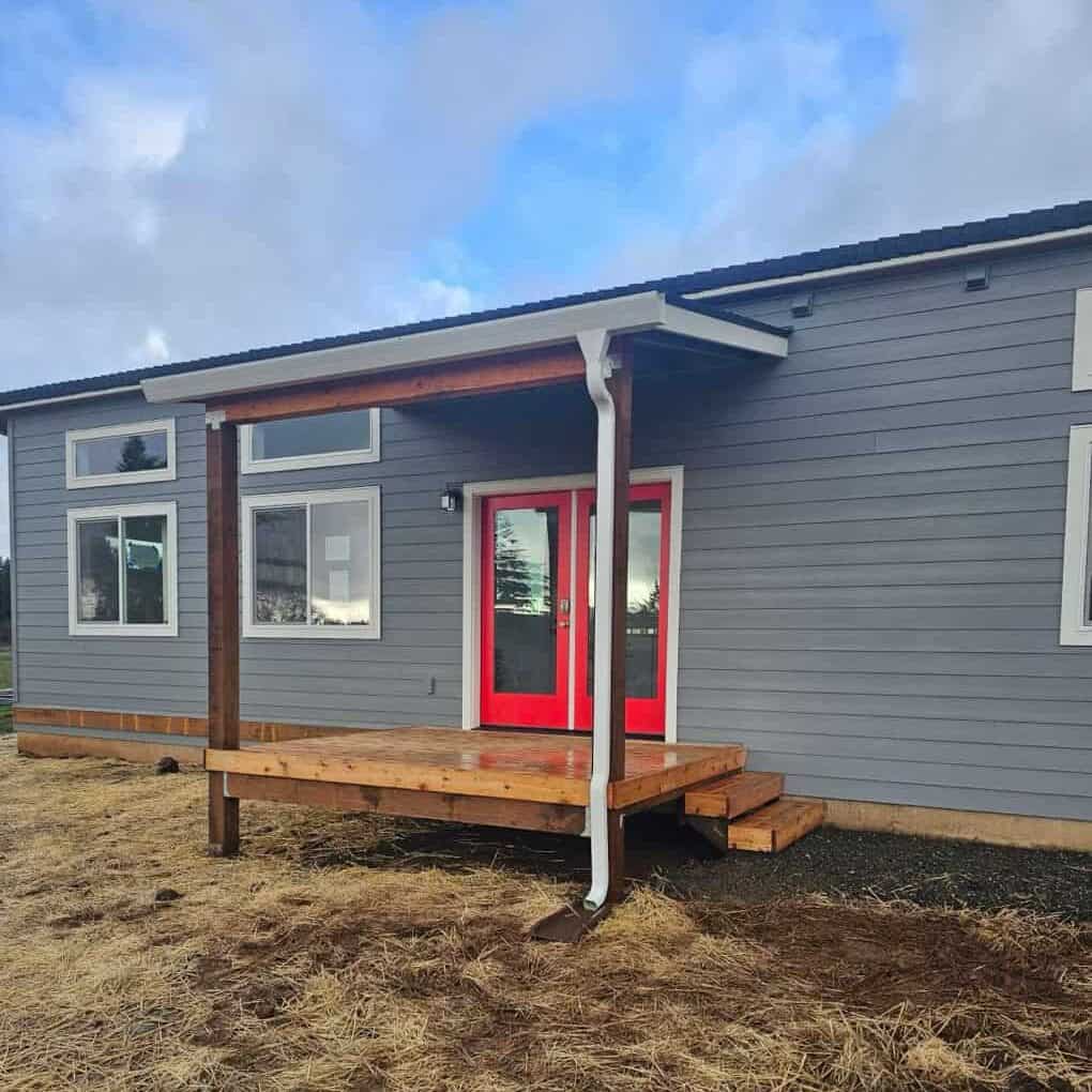 Grey and white Wolf Model E home with red French doors.